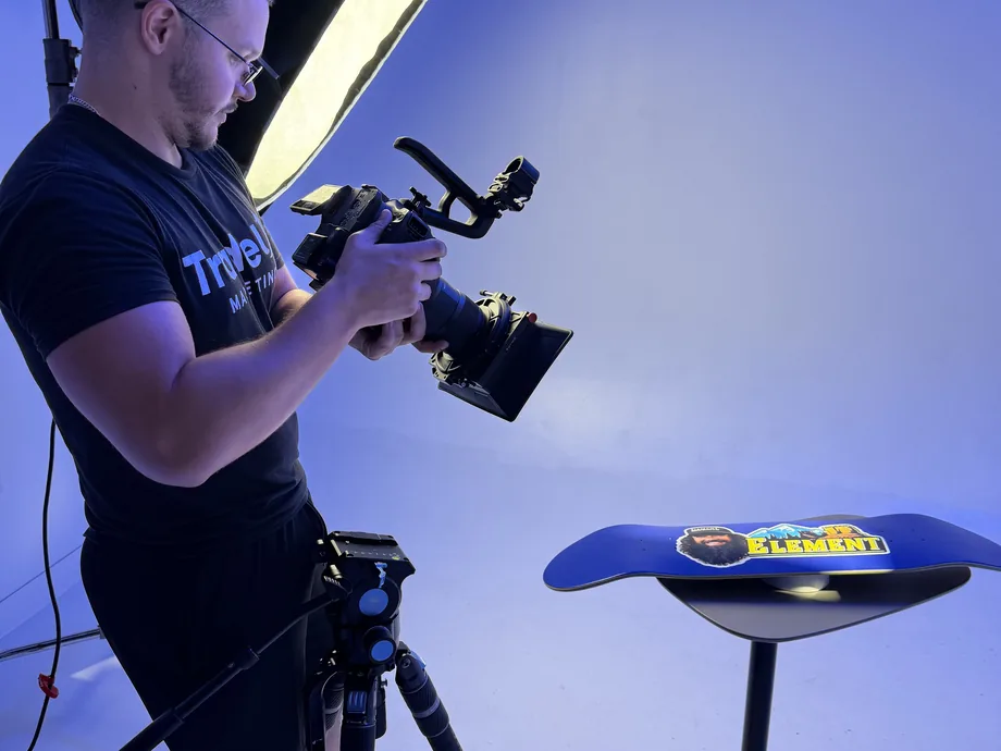 TradeUp Marketing videographer filming a custom skateboard deck during a studio product shoot