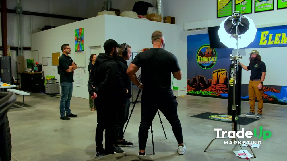 Crew lighting an Element Plumbing owner in front of the shop mural with a softbox