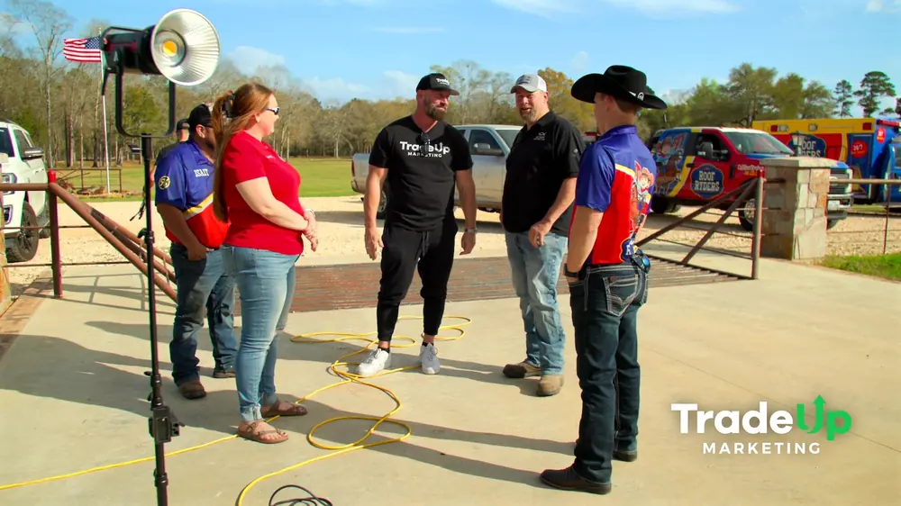 TradeUp crew directing the Roof Ryders team on location beside their wrapped trucks