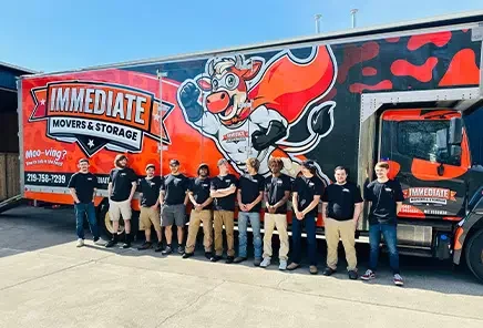 Immediate Movers project photo — the full crew lined up in front of a branded Immediate Movers & Storage truck